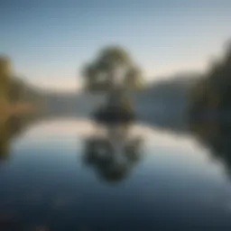 A serene landscape with a tranquil lake reflecting a clear blue sky